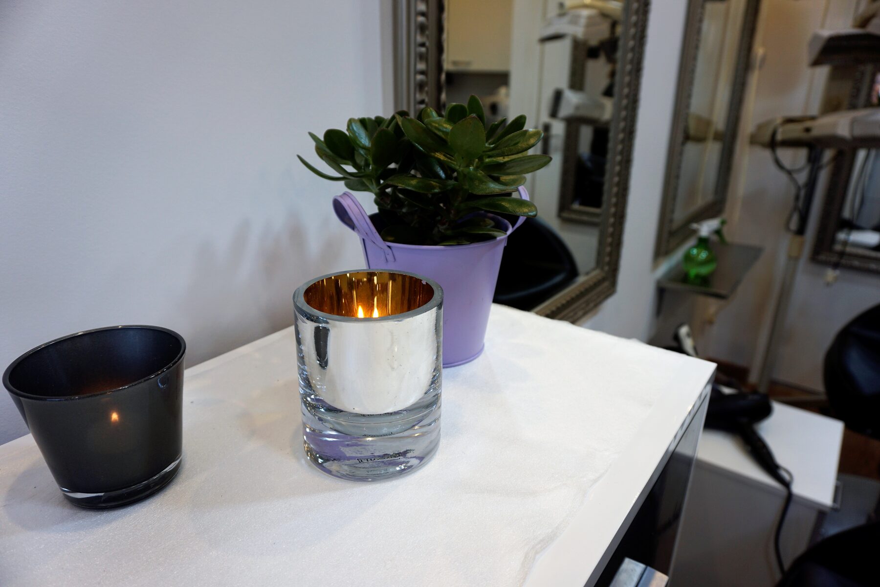 Kaars en plant op de toonbank van de salon