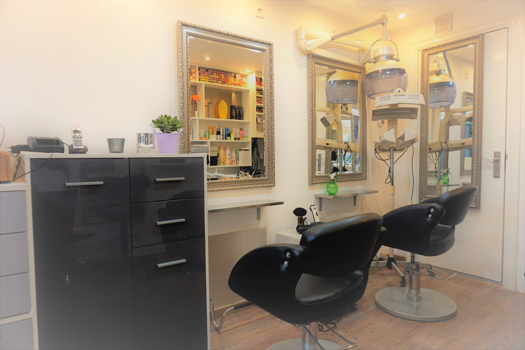 Het interieur van de salon met zwarte stoelen en zilveren spiegels